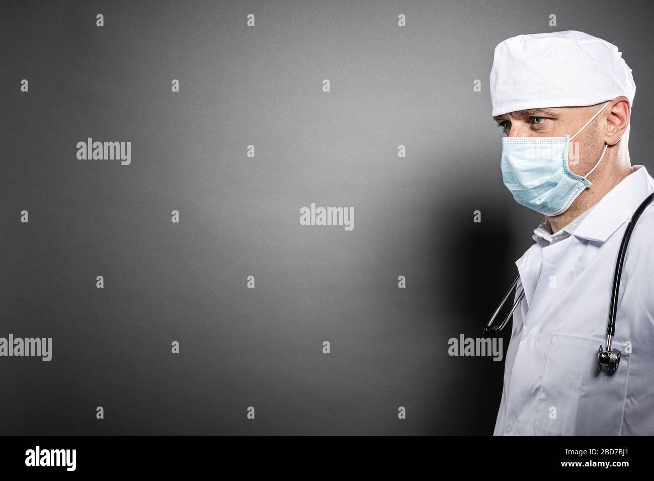 Arzt in medizinischer Maske auf grauem Hintergrund. Copyspace Stockfoto
