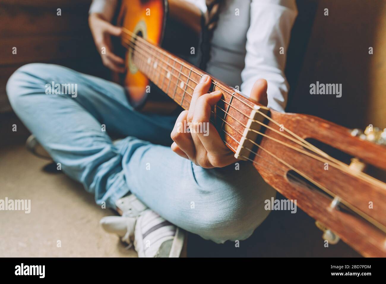 Bleib Zu Hause Bleib Sicher. Junge Frau, die zu Hause sitzt und Gitarre spielt, Hände nah dran. Teenager-Mädchen lernen, Lied zu spielen und Musik zu schreiben. Hobby Lifestyle Relax Instrument Freizeit Bildungskonzept Stockfoto