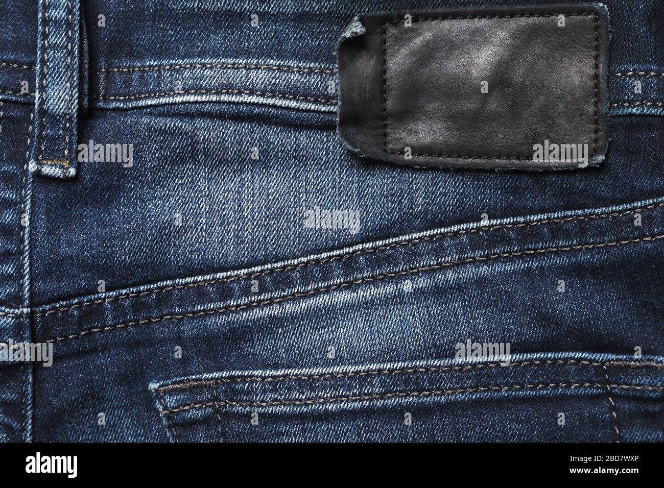 Jeans Rückseite Textur mit schwarzem Lederlabel. Stockfoto