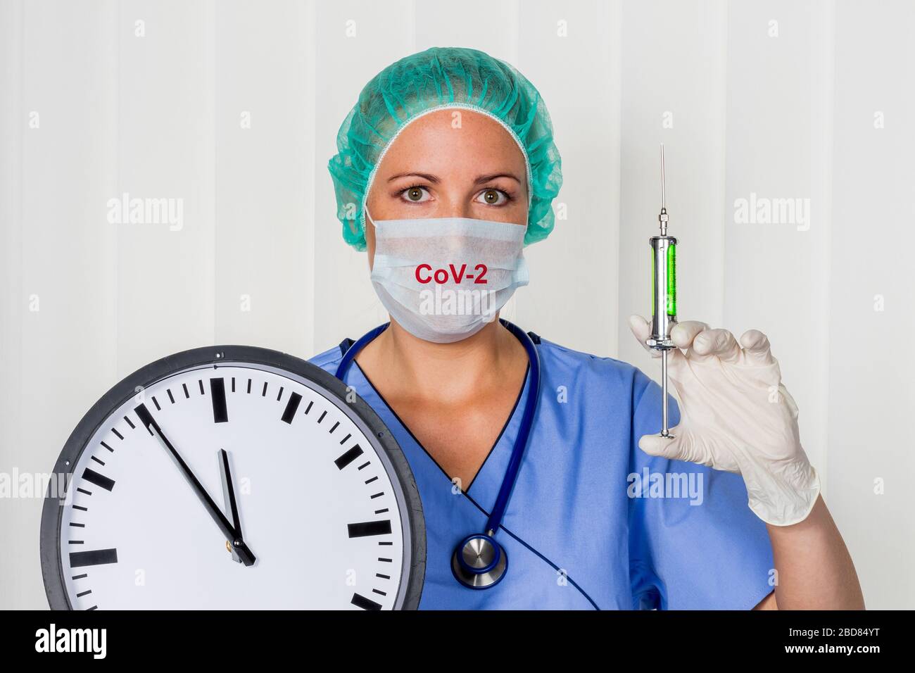 Chirurgie-Doktor in Srubs, mit einer Uhr, 5 vor 12, Coronavirus Pandemie Stockfoto