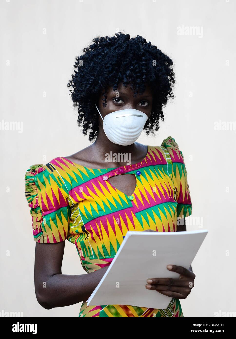 Wunderschöne schwarze Afrikanische Frau, die mit Gesichtsmaske posiert, um sich vor Infektionen, Bakterien und Viren zu schützen Stockfoto