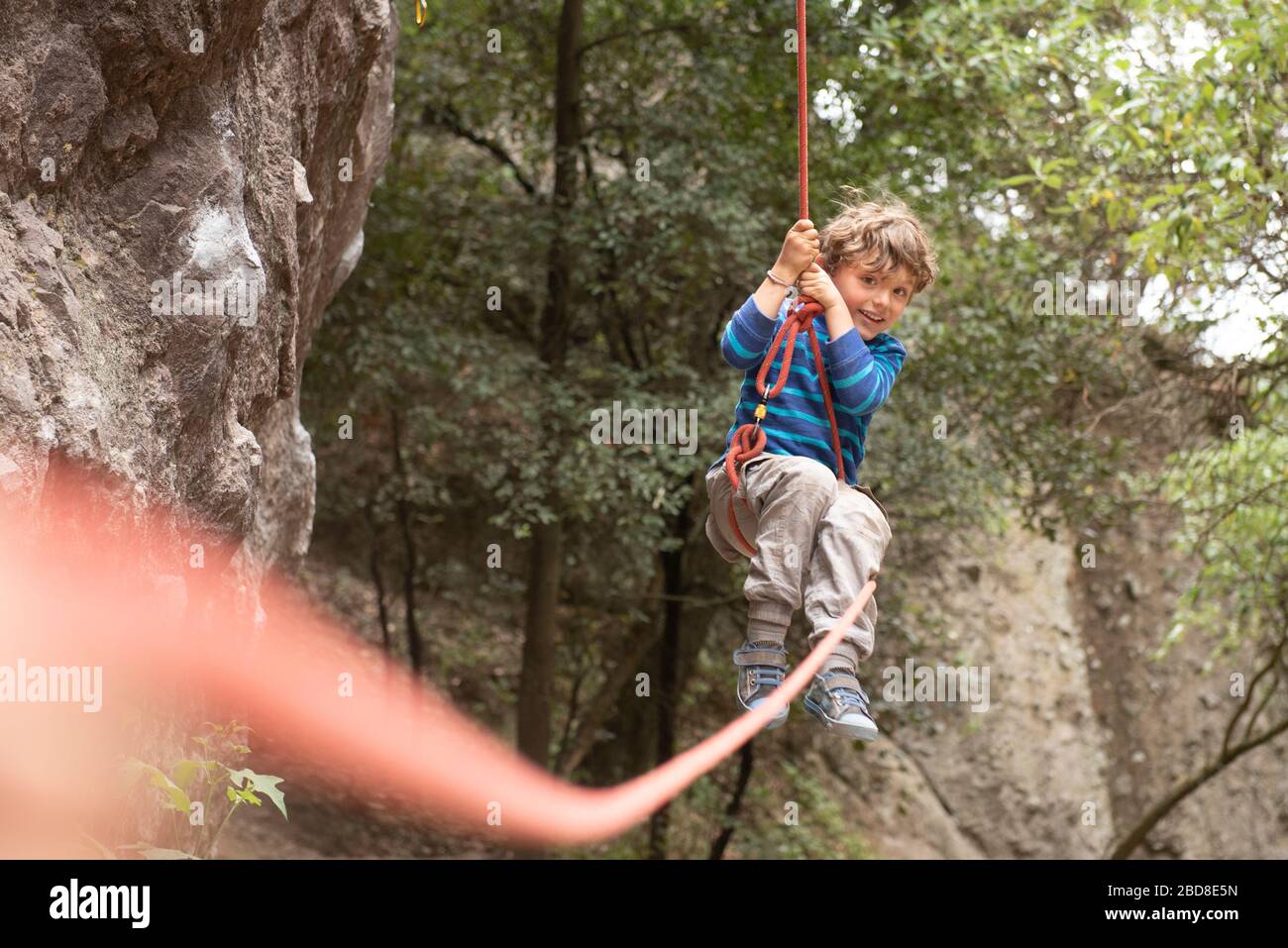 Vier Jahre altes Kleinkind Schaukeln hängen an einem Kletterseil Stockfoto