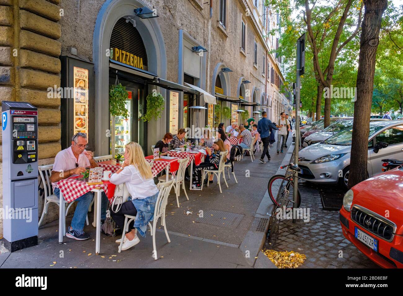 Essen im Freien, Leute essen an Tischen im Freien auf dem Bürgersteig in Ottavio Pizza e Spaghetti Pizzeria in Rom, Italien. Stockfoto
