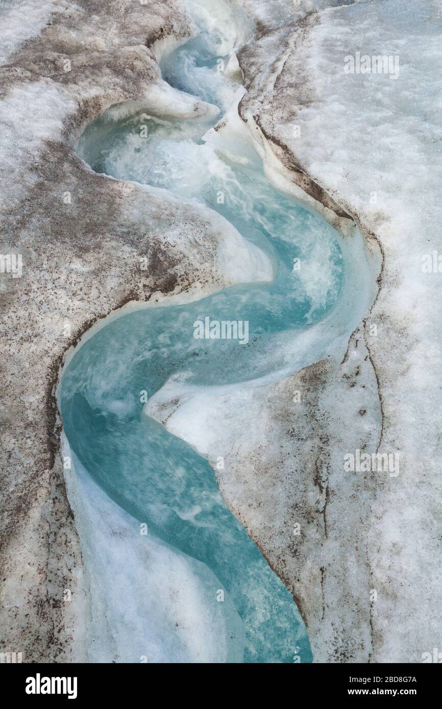 Schlängelnder Gletscher-Schmelzwasserstrom auf der Oberfläche des Snowbird-Gletschers, Talkeetna Mountains, Alaska. Stockfoto