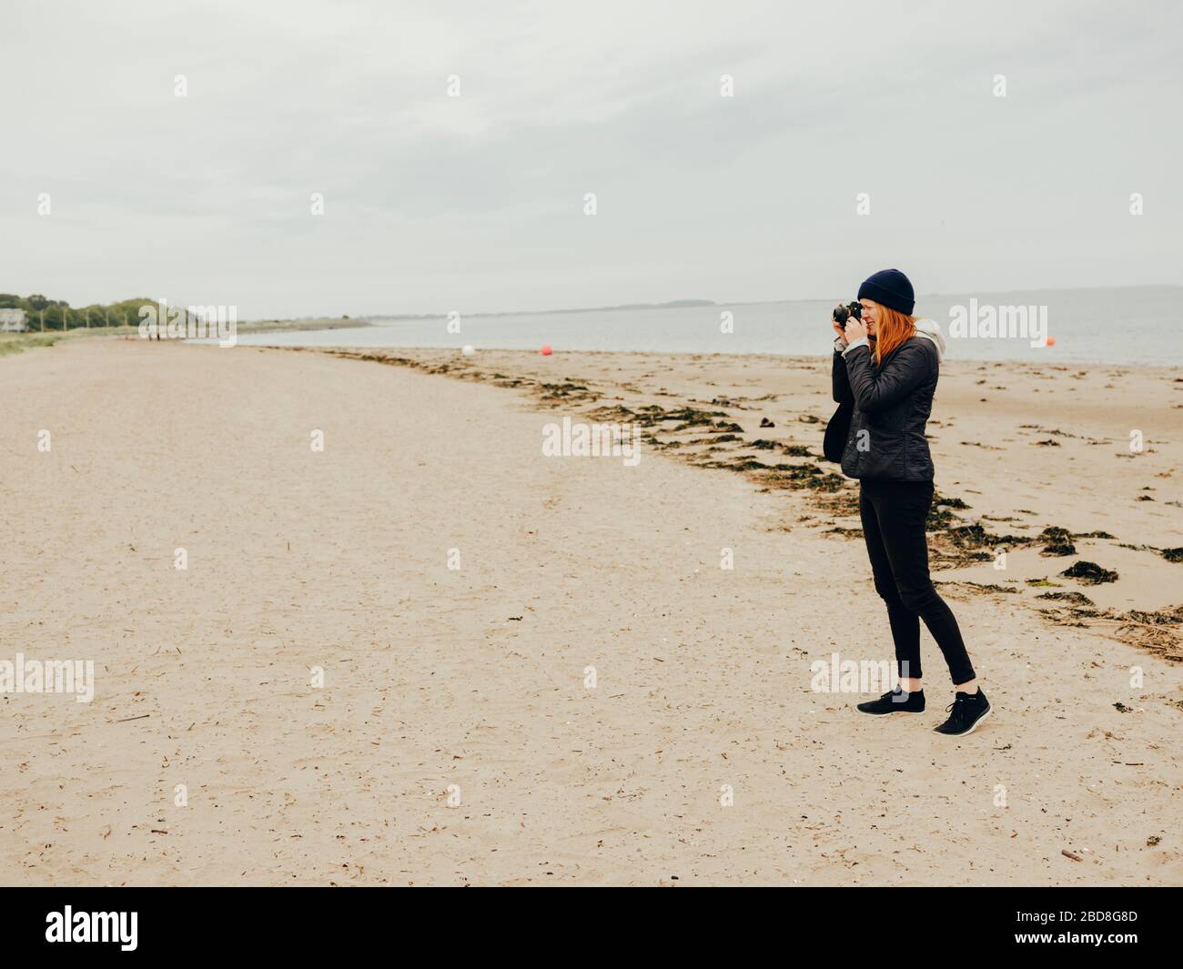 Frau, die am Strand in Schottland fotografiert Stockfoto