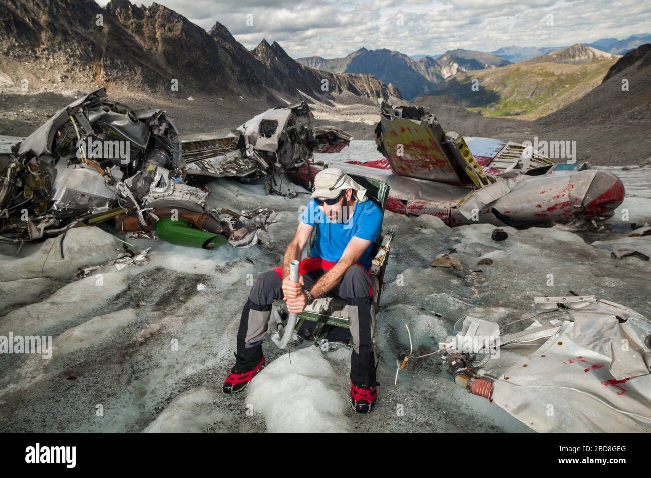 Ein Mann sitzt im Sitz eines abgestürzten Militärflugzeugs auf dem Bomber-Gletscher, den Talkeetna Mountains, Alaska. A TB-29 Superfortress (Trainer B-29-Bomber) cras Stockfoto