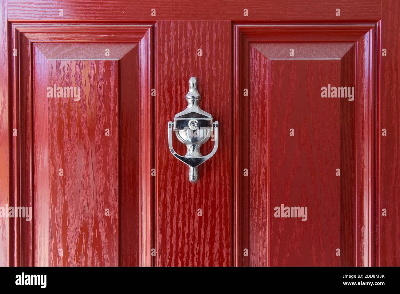 Neu lackierte rote Tür mit Chrom Türklopfer Stockfoto