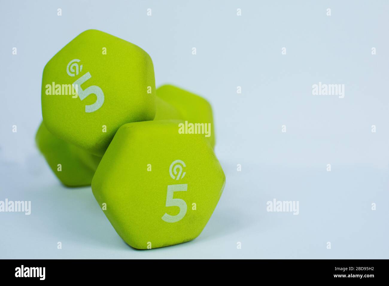 2 Neon Green 5 lb Gewichte auf weißem Hintergrund Stockfoto