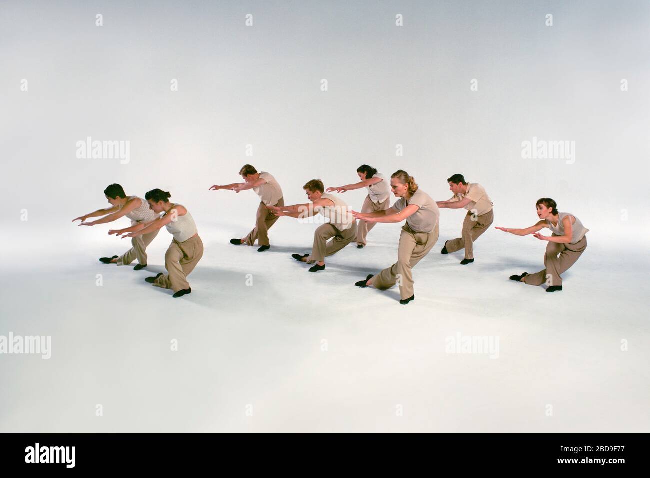 Moderne Tänzer (Modell veröffentlicht) treten auf weißer nahtloser Bühne auf. Stockfoto