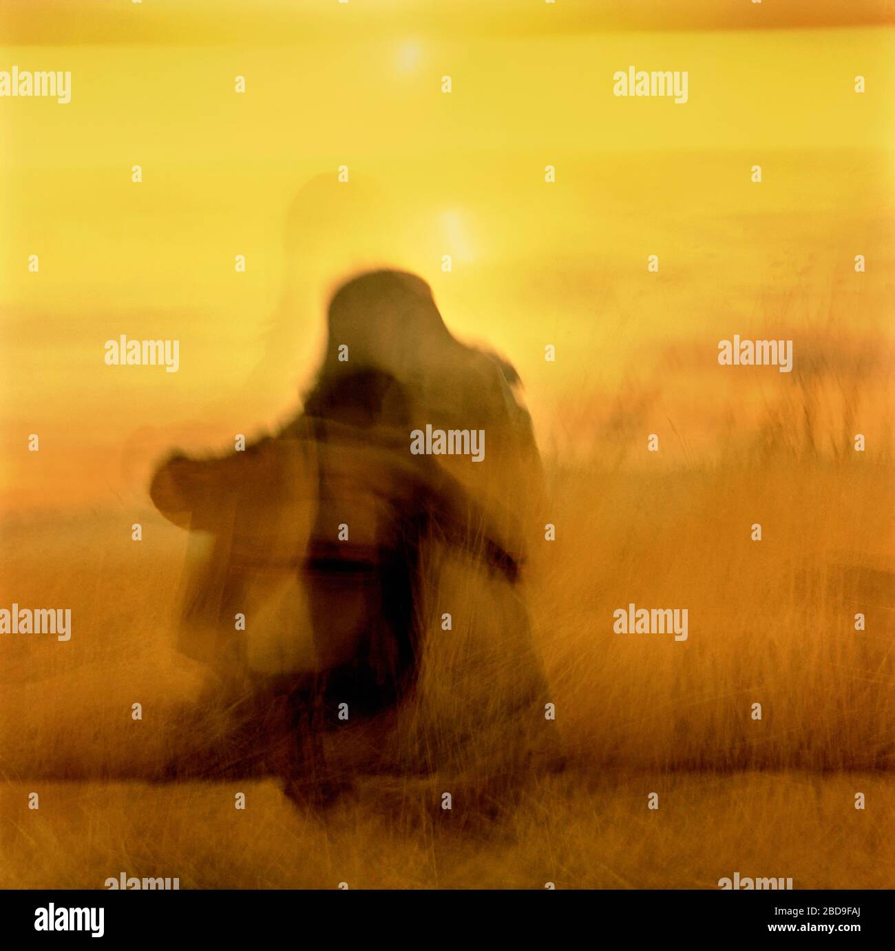 In der Farbbewegung der Kamera abstrakt von Tänzerin auf grasbestängem Feld nahe Sonnenuntergang in Logan, Utah. Stockfoto