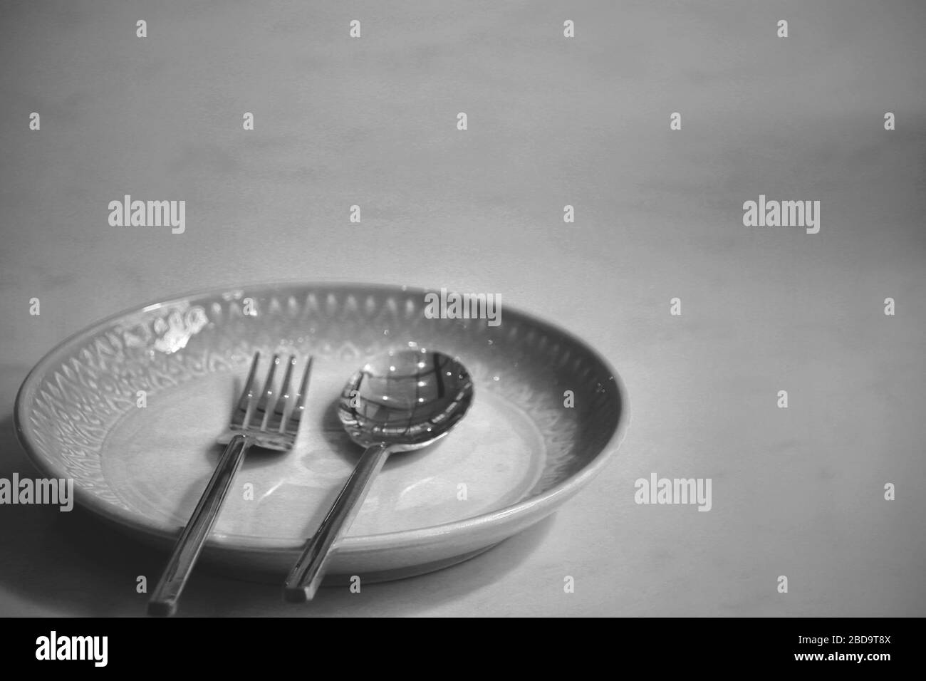 Leerer Teller in einem geschlossenen Restaurant zeigt die Einsamkeit, Wirtschaftskrise, Hunger und Depression als Folge sozialer Distanzierung, Sperrung und Ich Stockfoto