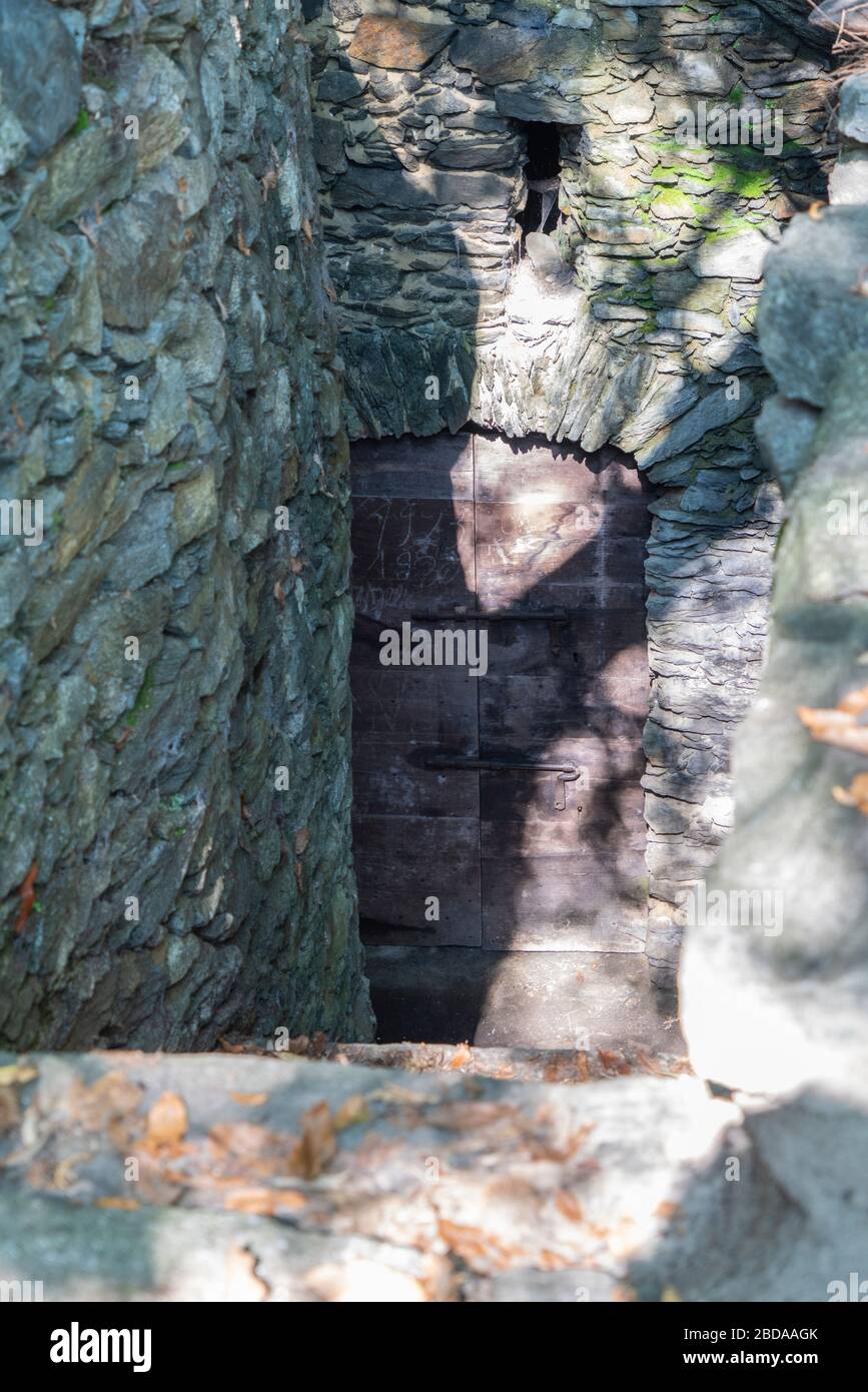Eingangstür zum unterirdischen Weinkeller, der in den Felsen gehauen ist, Costiera dei Cech, Valtellina, Provinz Sondrio, Lombardei, Italien Stockfoto