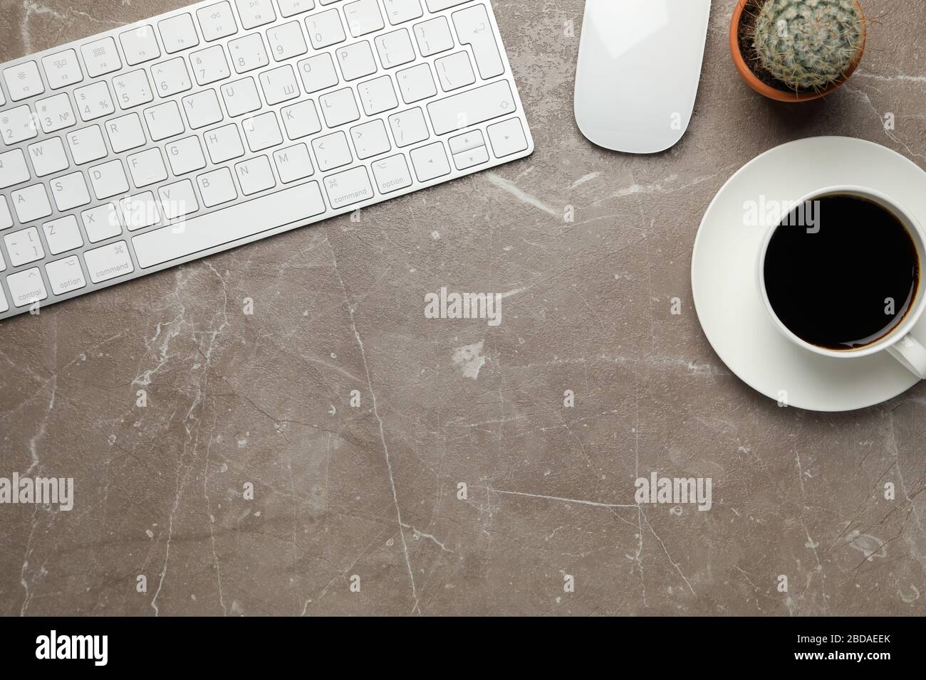 Arbeitsplatz mit Tastatur, Maus, Kaffee und Kaktus, Platz für Text Stockfoto