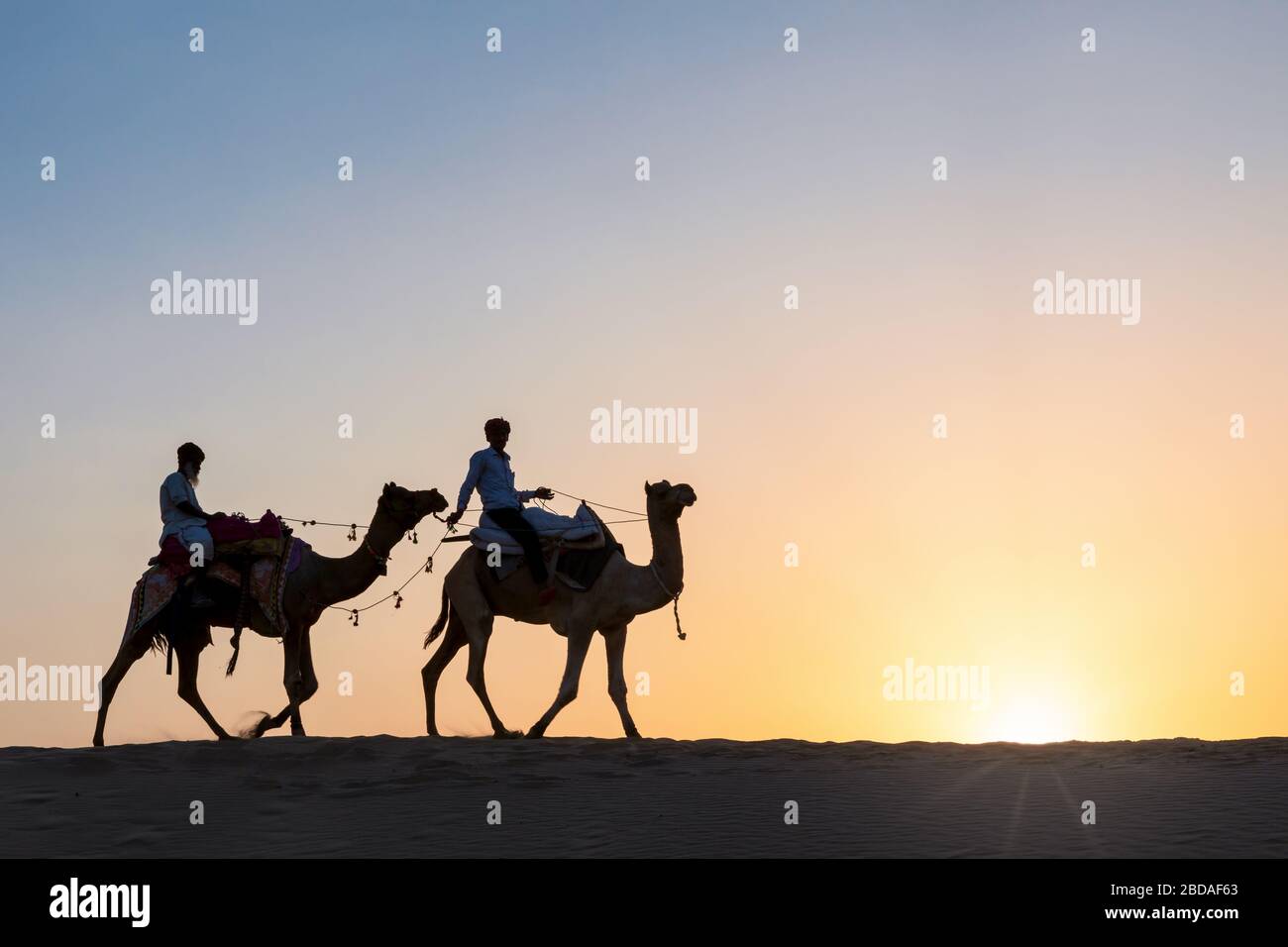 Zwei Männer auf Kamelen in der Thar-Wüste bei Sonnenuntergang, Rajasthan, Indien Stockfoto