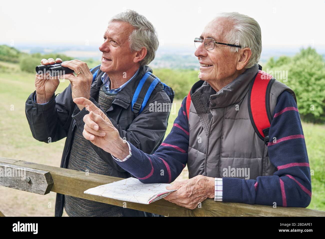 Zwei Pensionierte männliche Freunde auf Urlaub durch ein Fernglas Stockfoto Zwei Pensionierte männliche Freunde auf Urlaub durch ein Fernglas Stockfoto