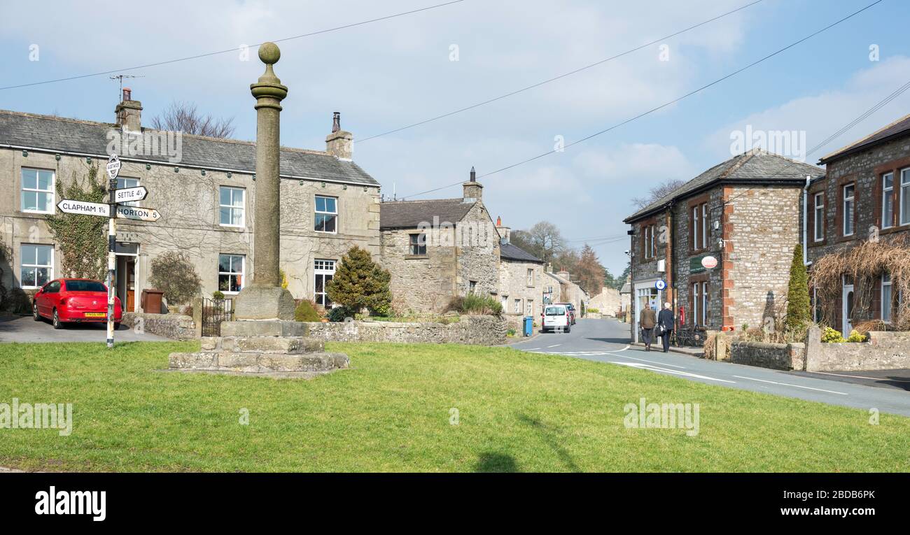 Das Marktkreuz und das Dorfgrün im Zentrum des Yorkshire Dales Dorfes Austwick Stockfoto