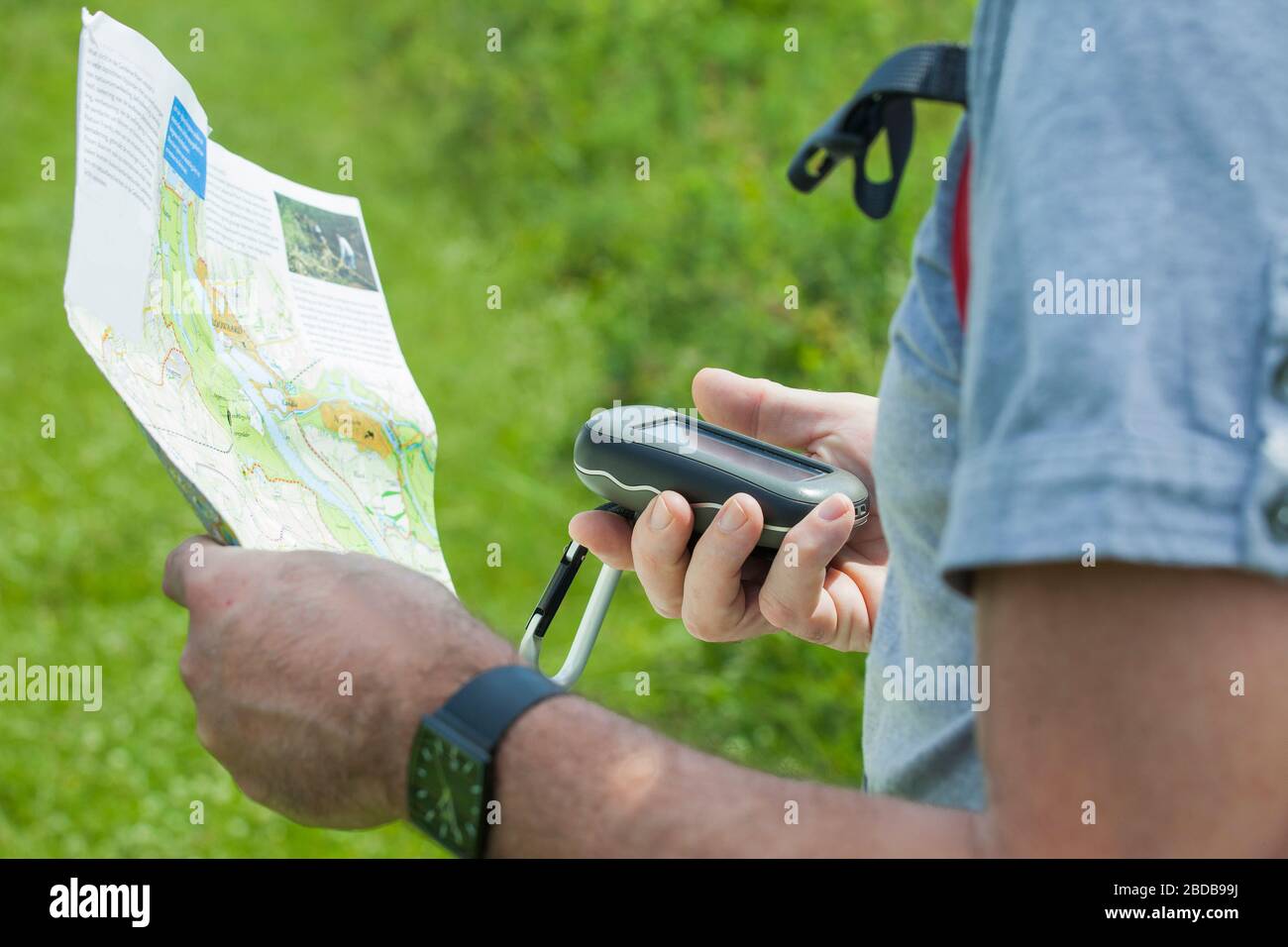 Mann hält einen GPS-Empfänger und plant in der Hand. Handheld-GPS-Geräte werden überwiegend in der Freizeitreisenbranche zum gehen und Wandern eingesetzt. Stockfoto