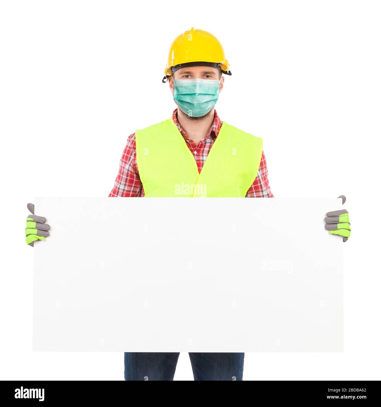 Handarbeiter mit Sicherheitsmaske, gelbem Helm und reflektierender Weste halten weißes Schild. Studio mit drei Viertel Länge wurde isoliert aufgenommen Stockfoto