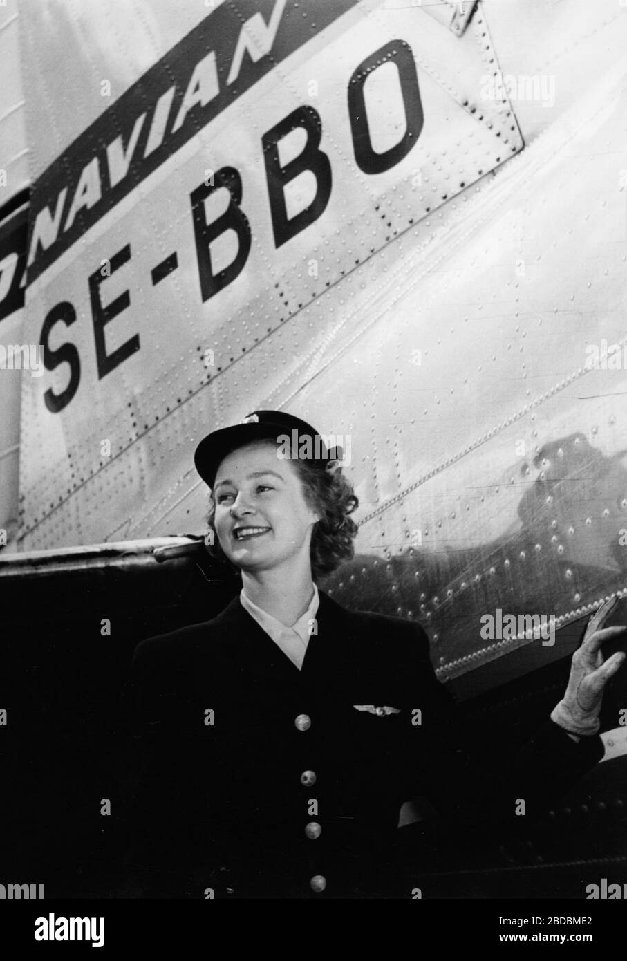 Britt Hansson, Lufthostess. ABA-Uniform 1946-1951 und SAS 1946-1948 hatten die gleichen Uniformen, aber verschiedene Knöpfe und Flügel. Air Hostess Britt Hansson an der Front von DC-3, Orvar viking, SE-BBO 40er. Stockfoto