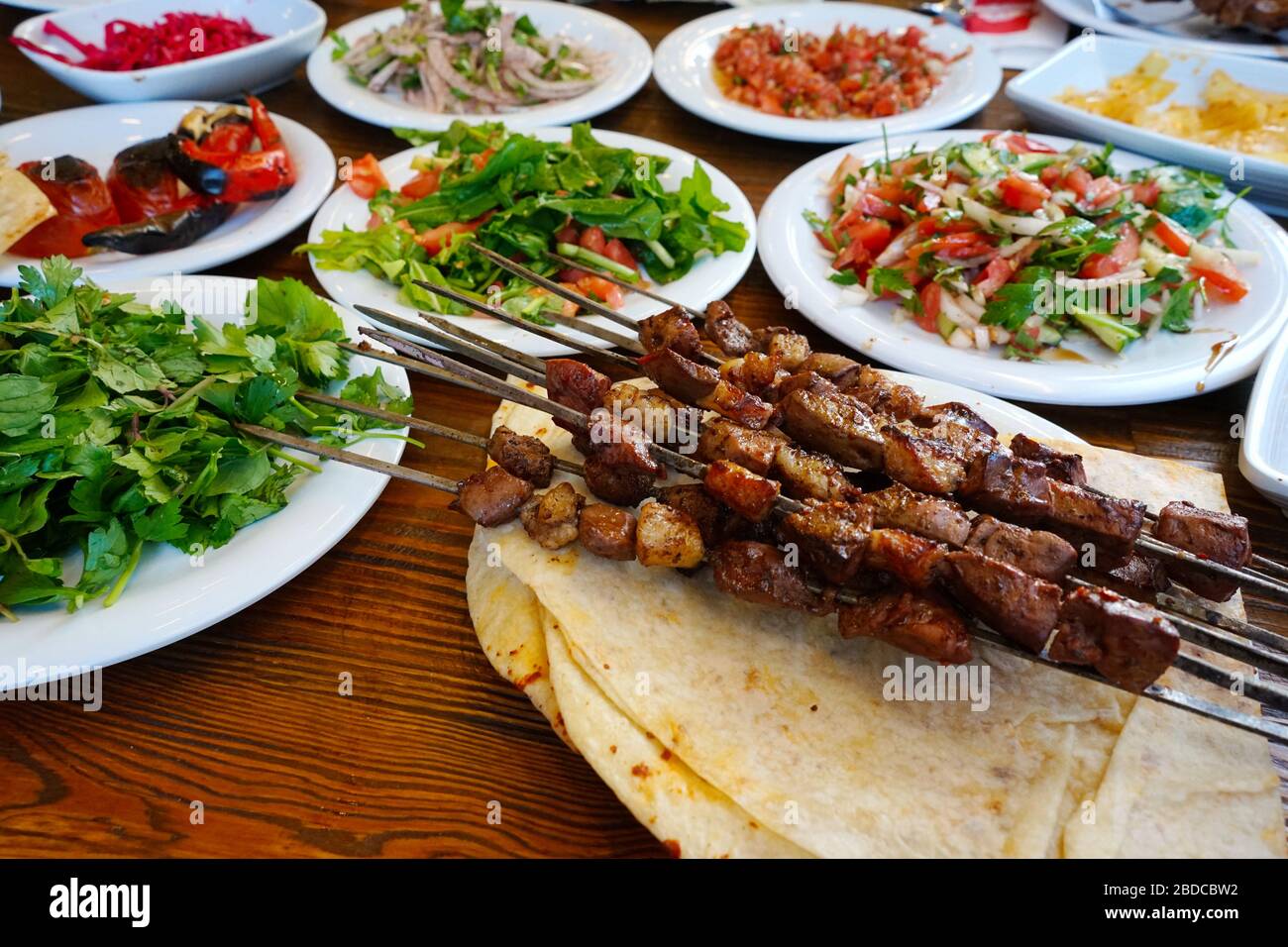 Leberkebab. Der Tisch wird auch mit türkischen Vorspeisen und Salatsorten serviert. Eine Art Kebab, die oft in den südlichen Provinzen der Türkei gemacht wurde. Aus Stockfoto