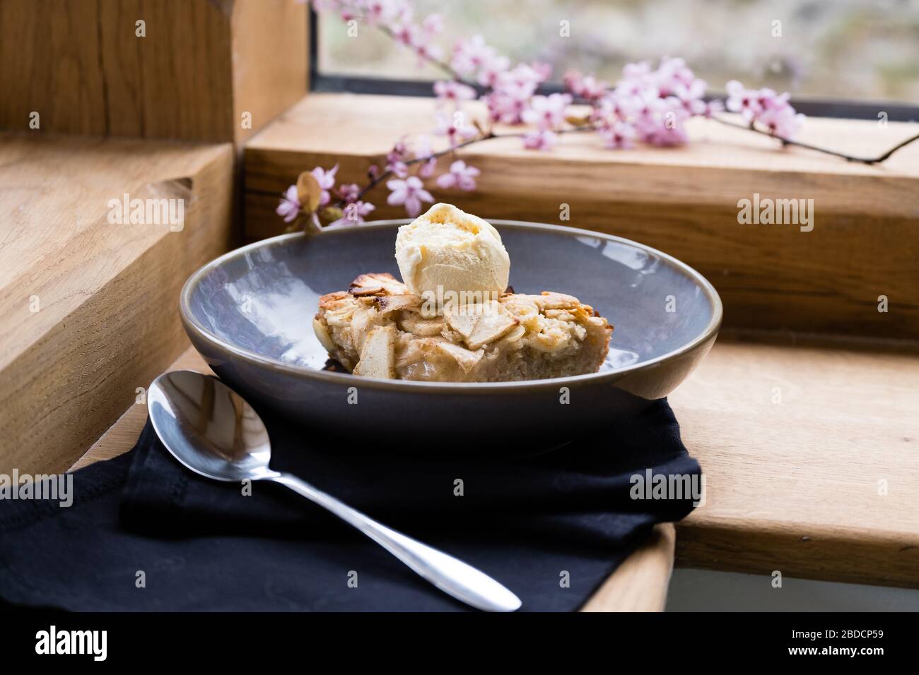 Apfelkuchen und Eis in einer Schüssel mit Löffel Stockfoto