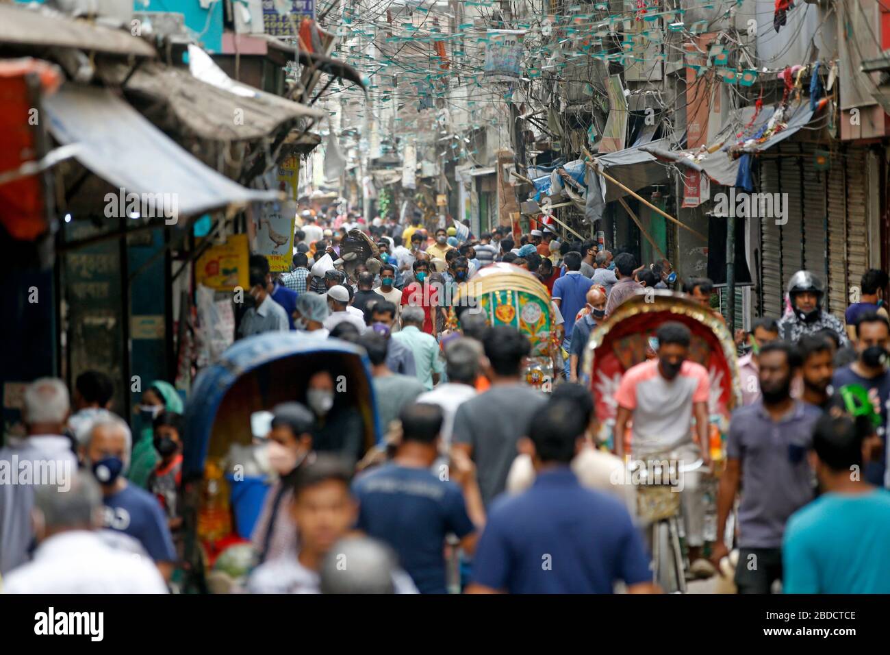 Die Leute drängen sich auf dem Küchenmarkt im alten Dhaka, um Lebensmittel und das tägliche Notwendige zu kaufen, und setzen sich selbst und andere dem Risiko des Coronavirus aus Stockfoto