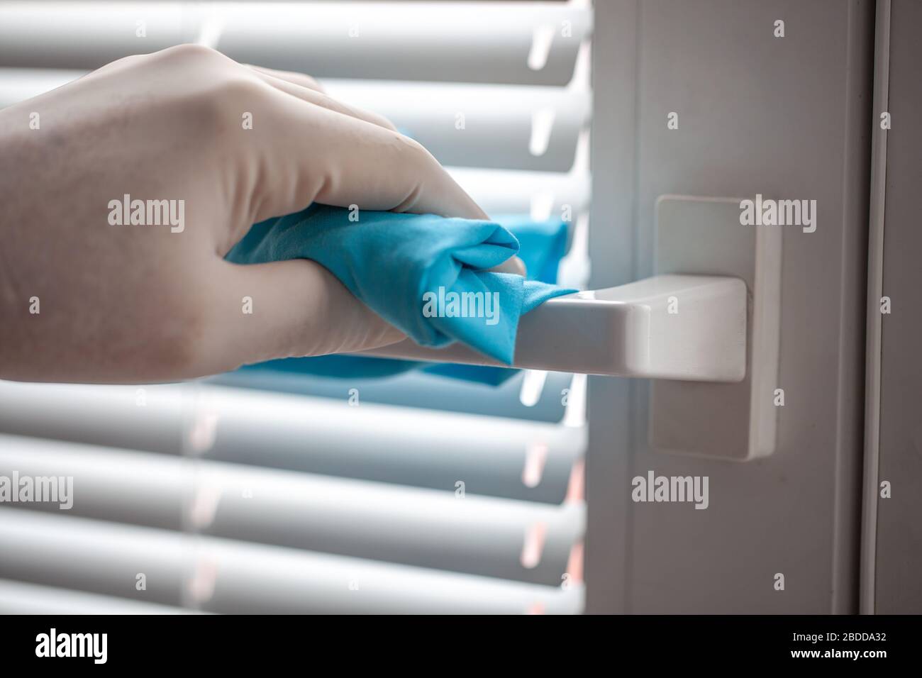 Reinigung und Desinfektion von Türgriffen und Fenstergriffen mit Reinigungstuch gegen Viren und Keime. Stockfoto