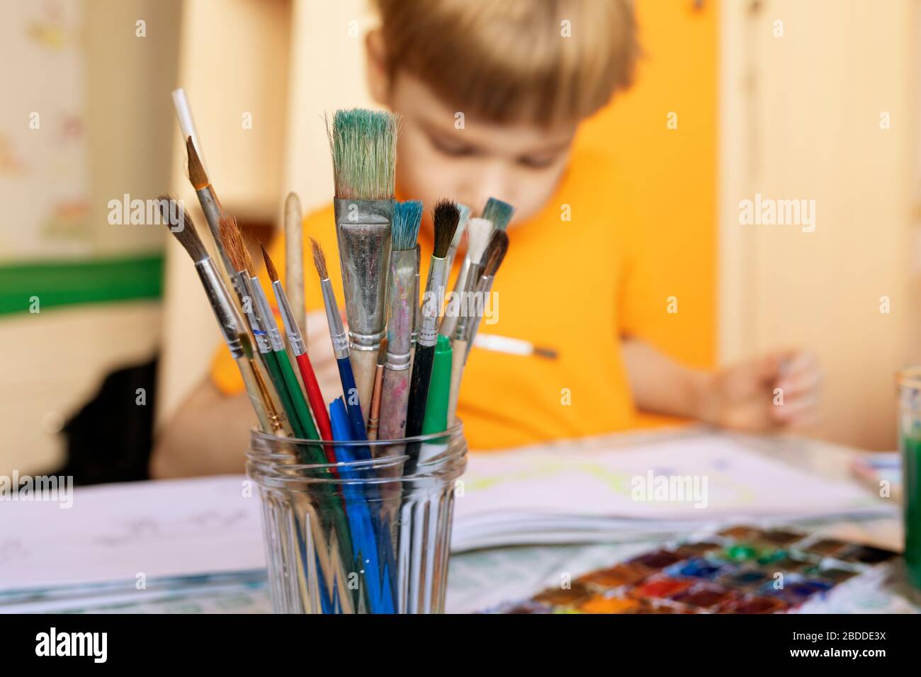 Malpinsel auf unscharfem Hintergrund von Farbe und Junge beschäftigen sich mit der Malerei. Kreative Aktivitäten für Kinder zu Hause. Freizeit zu Hause mit Kindern Stockfoto
