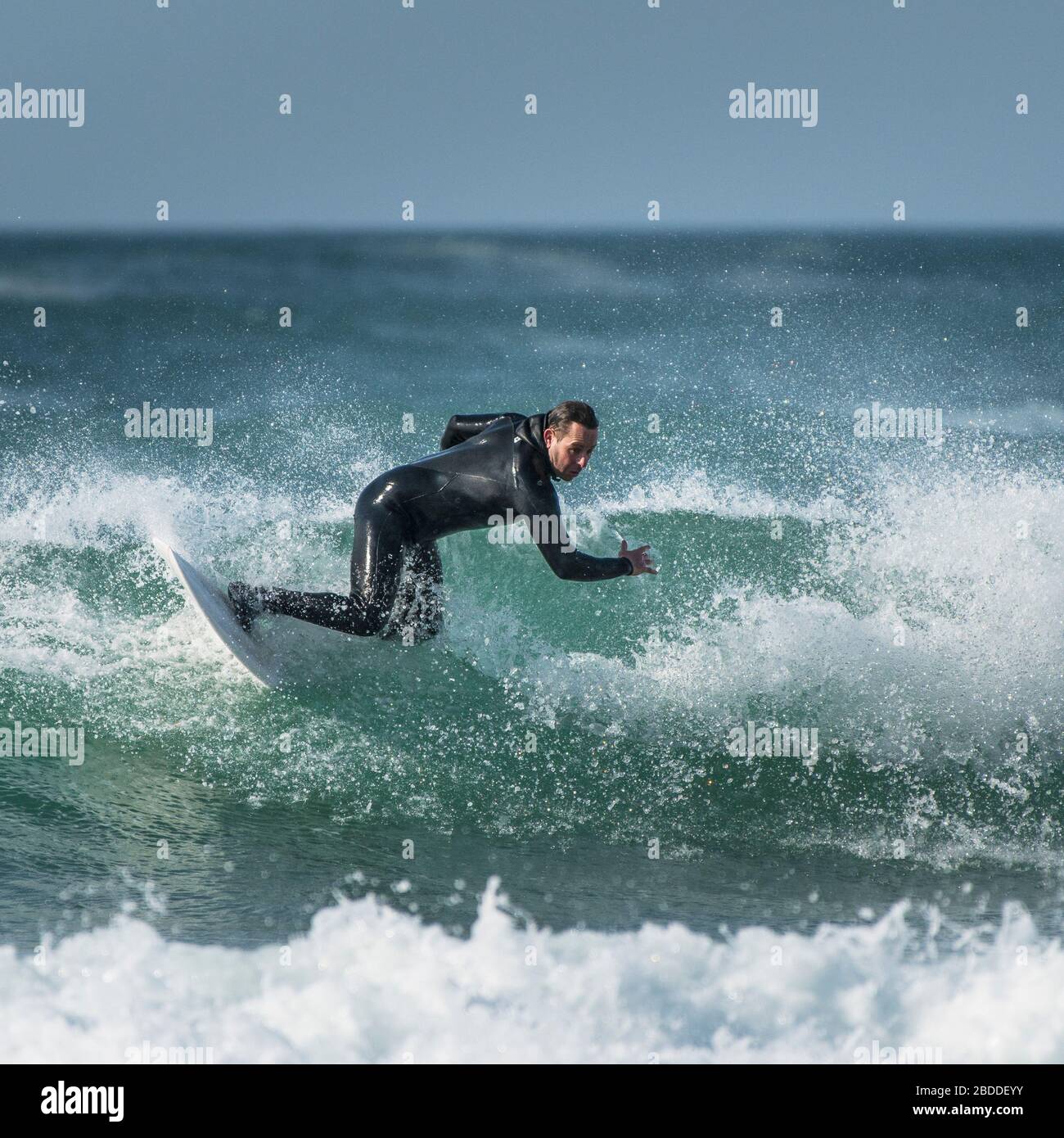 Ein reifer Surfer, der die spektakulären Surfbedingungen in Fistral in Newquay in Cornwall genießt. Stockfoto