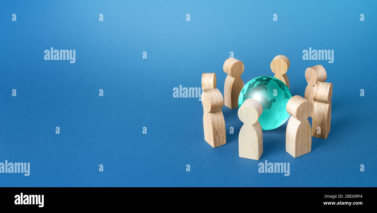 Menschen umgeben einen blauen Erdglobus. Zusammenarbeit und Zusammenarbeit. Zusammenarbeit zur Lösung globaler Probleme. Verhandlungen. Teamarbeit. Remote-Arbeit und Sie Stockfoto