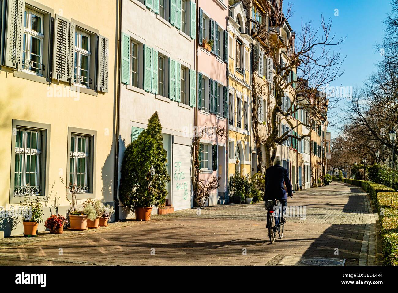 Eine Person, die eine ruhige Wohnstraße im Stadtzentrum von Basel, Schweiz, entlang radelt. Februar 2020. Stockfoto