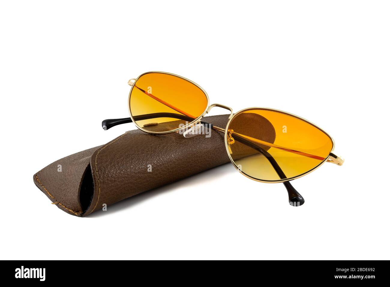 Orangefarbene Sonnenbrille mit goldenen Umrandungen und braunen Brillen, isoliert auf weißem Hintergrund, gefaltete Seitenansicht Stockfoto