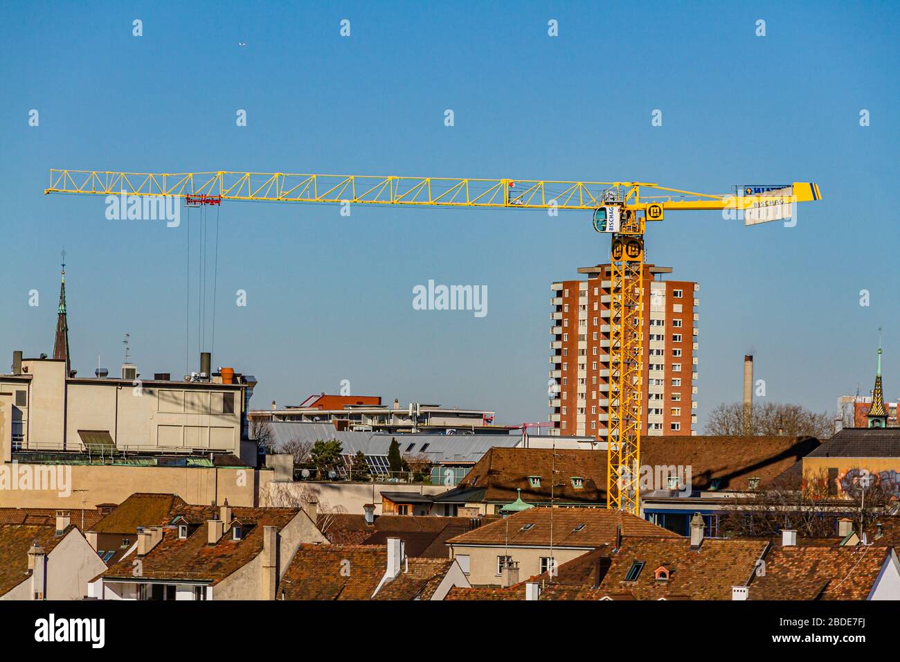 Ein Baukran über Dächern in der Stadt Basel, Schweiz. Februar 2020. Stockfoto