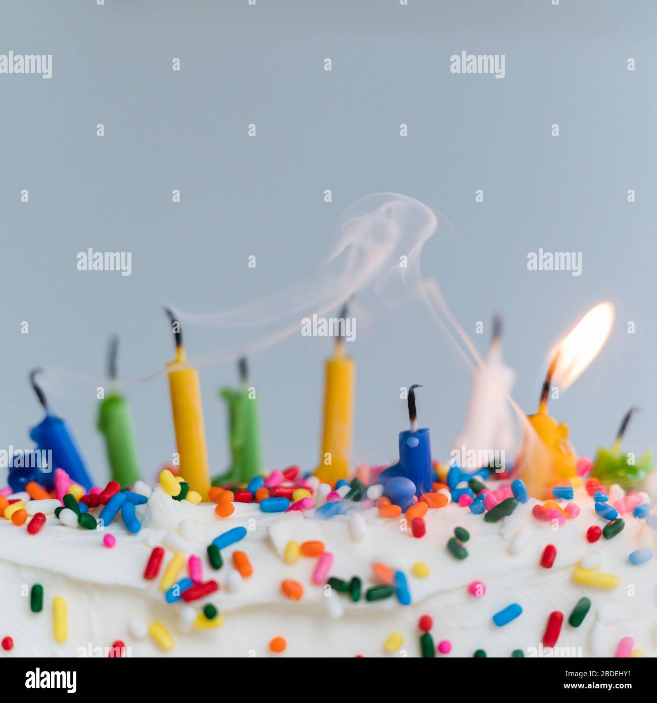 Erloschene Geburtstagskerzen auf Kuchen - eine noch brennend Stockfoto