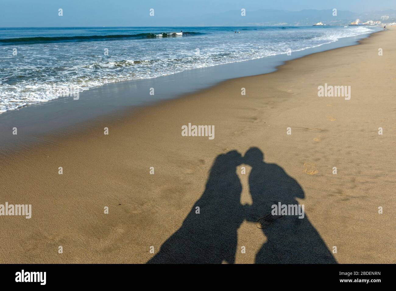 Schatten des Kussens eines Paares am Santa Monica Beach Stockfoto