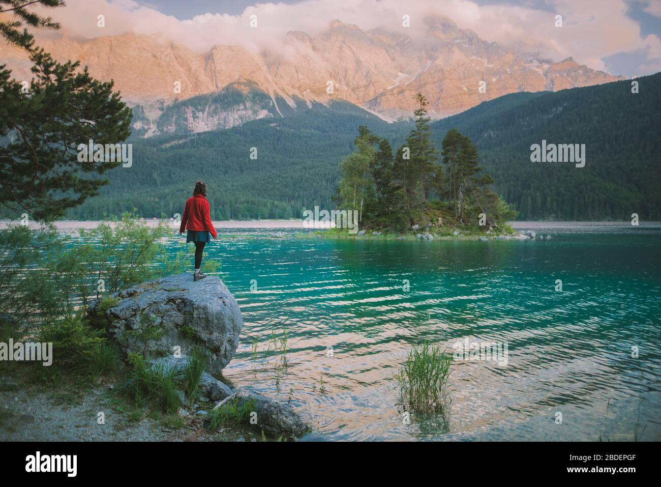 Deutschland, Bayern, Eibsee, Junge Frau auf Felsen am Eibsee in den bayerischen Alpen Stockfoto