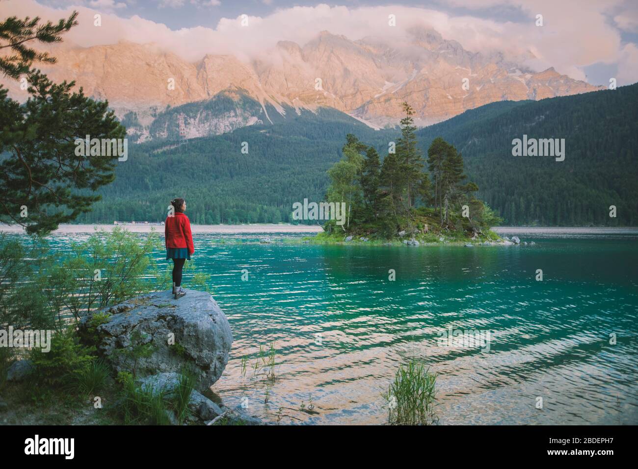 Deutschland, Bayern, Eibsee, Junge Frau auf Felsen am EibseeÂ-See in den bayerischen Alpen Stockfoto