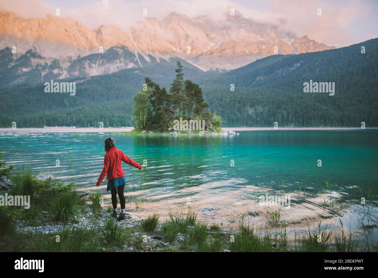 Deutschland, Bayern, Eibsee, Junge Frau beim Spaziergang am Ufer des Eibsees in den bayerischen Alpen Stockfoto