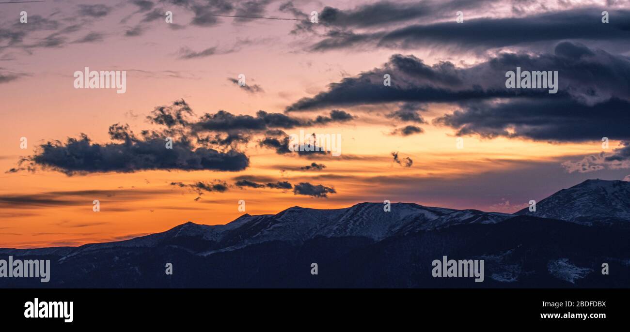 Kräftiger oranger Sonnenuntergang in den Bergen am Abend Stockfoto