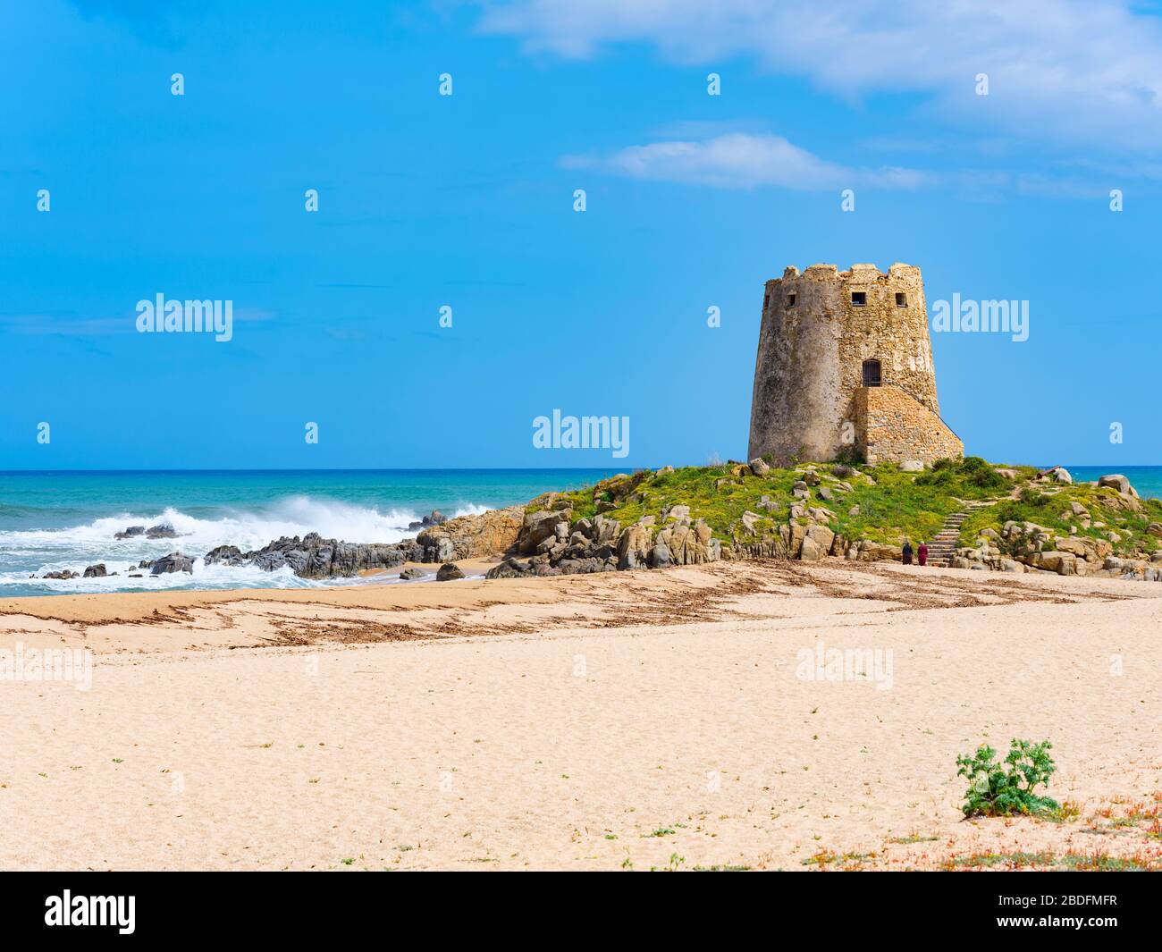 Das Wahrzeichen der Stadt Bari Sardo, der Torre di Barì, ein Turm, der auf einem Felsvorsprung am Strand mit beigem Sand und kristallklarem Wasser erbaut wurde Stockfoto