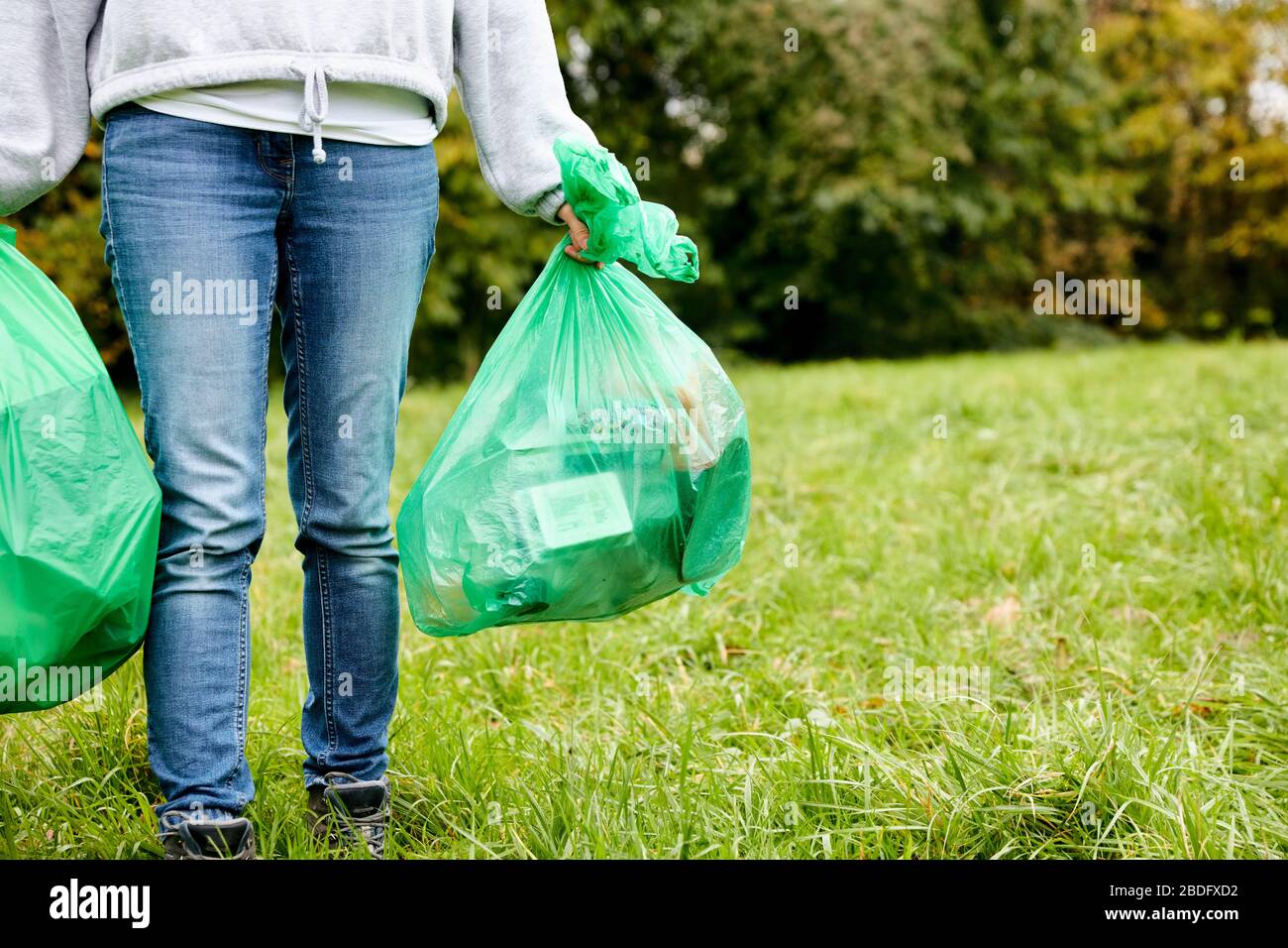 Frau betufft weiche Kunststoffabfälle in große Plastikflaschen, um einen Ökobrick herzustellen, der dann als Bruderblock verwendet werden kann Stockfoto