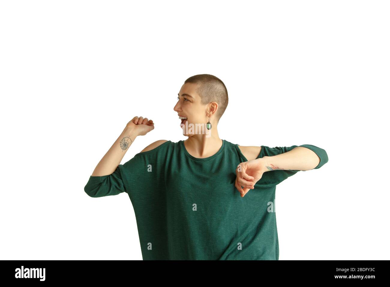 Tanzen. Porträt der jungen kaukasischen Frau mit freizügiger Erscheinung auf weißem Hintergrund. Ungewöhnlicher Look mit Tätowierungen und Glatze. Menschliche Emotionen, Gesichtsausdruck, Umsatz, Anzeigenkonzept. Jugendkultur. Stockfoto