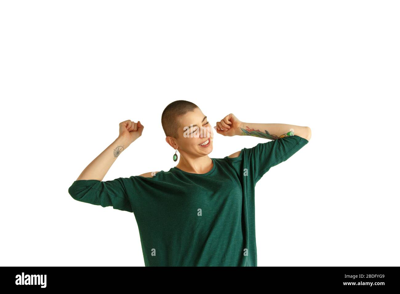 Tanzen. Porträt der jungen kaukasischen Frau mit freizügiger Erscheinung auf weißem Hintergrund. Ungewöhnlicher Look mit Tätowierungen und Glatze. Menschliche Emotionen, Gesichtsausdruck, Umsatz, Anzeigenkonzept. Jugendkultur. Stockfoto