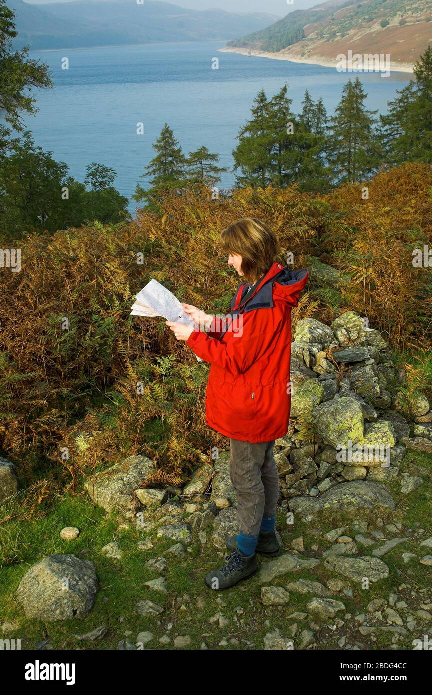 Frau, die eine Karte der Ordance Survey auf einem Spaziergang durch Haweswater im englischen Lake District, Cumbria, Großbritannien liest. Stockfoto