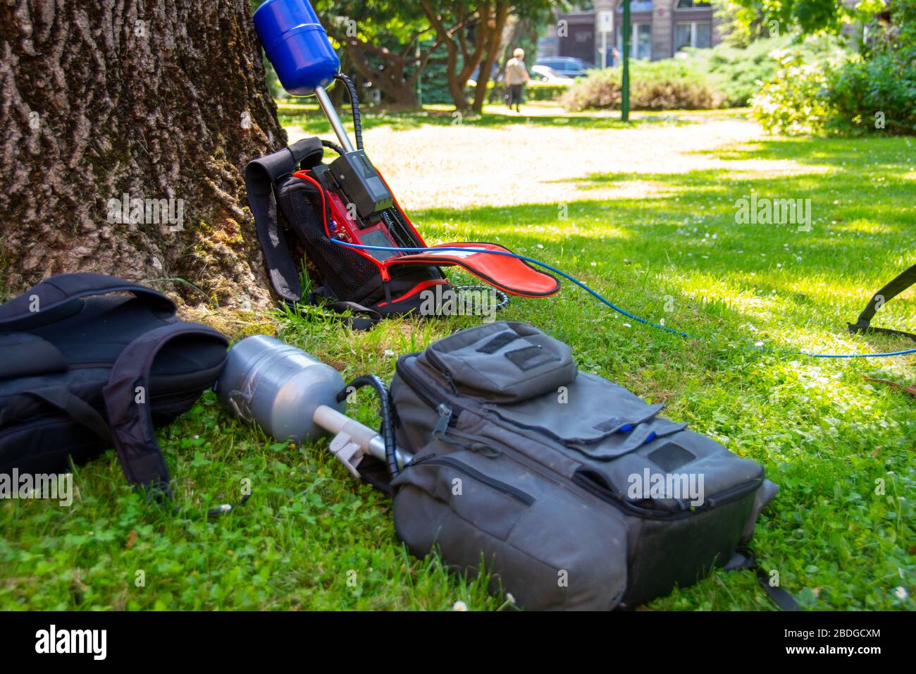 Ausrüstung einer Nachrichtenbesatzung in einem Park, die während des Interviews auf Gras blieb Stockfoto