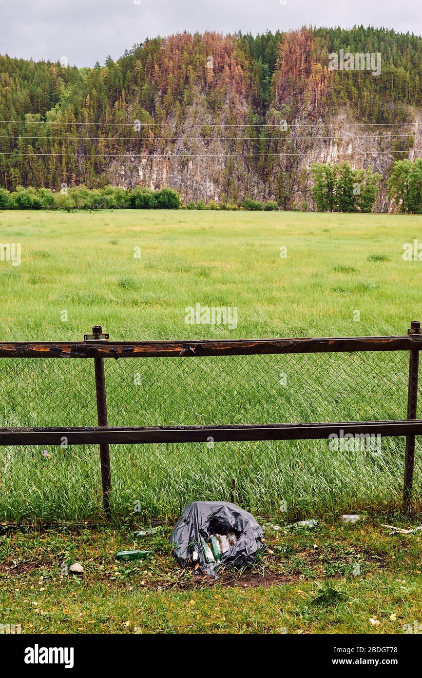 Ein Haufen Müll auf einem Hintergrund schöner Natur. Umweltverschmutzung durch den Menschen. Stockfoto