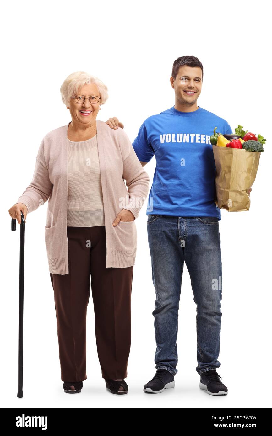 Porträt einer älteren Frau, die mit einem jungen männlichen Freiwilligen steht und ihre Einkaufstasche auf weißem Hintergrund isoliert trägt Stockfoto