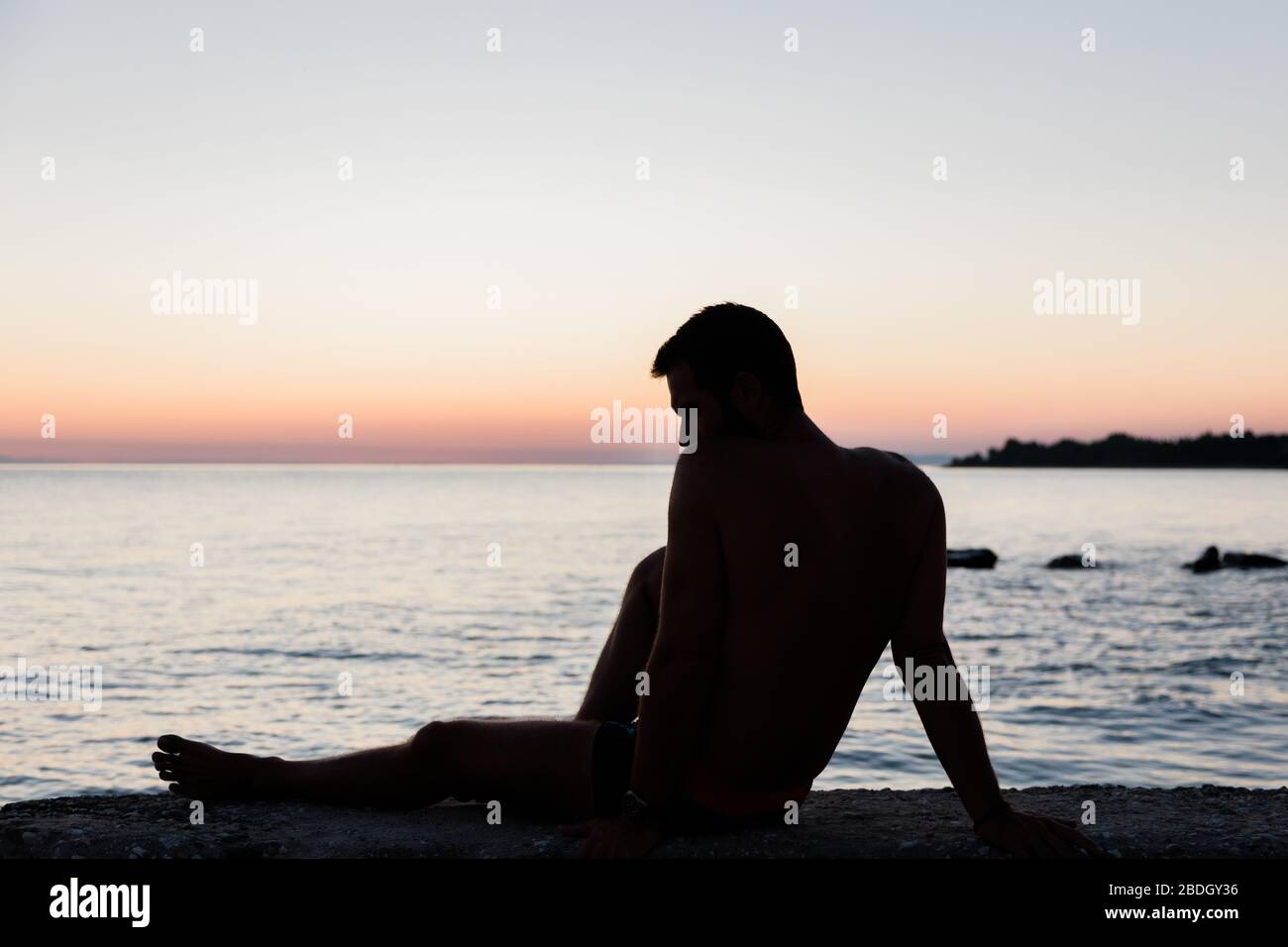 Silhouette eines Mannes am Meer bei Sonnenuntergang Stockfoto