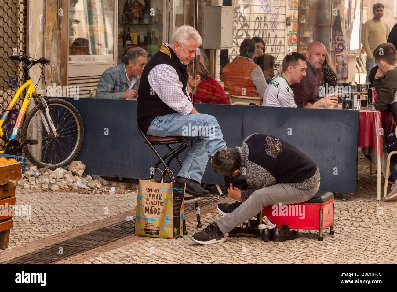 Lissabon, Portugal - 8. März 2020: Ein Schuh glänzt mit Schuhen auf der Straße Stockfoto