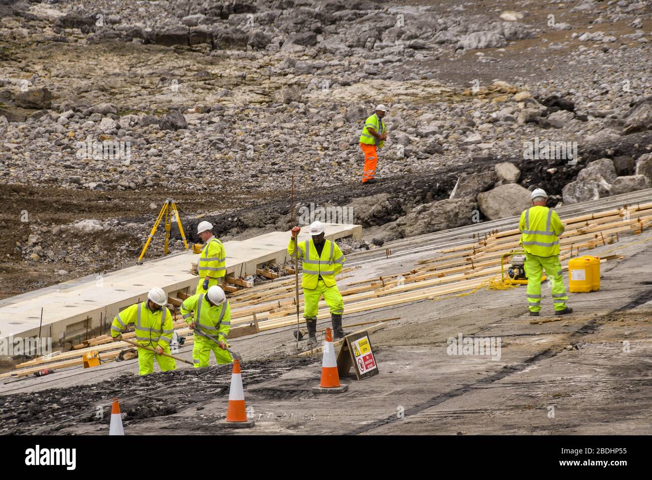 PORTHCAWL, WALES - JUNI 2018: Bauarbeiter arbeiten bei Ebbe an der Sanierung der Strandpromenade vor der Promenade Stockfoto